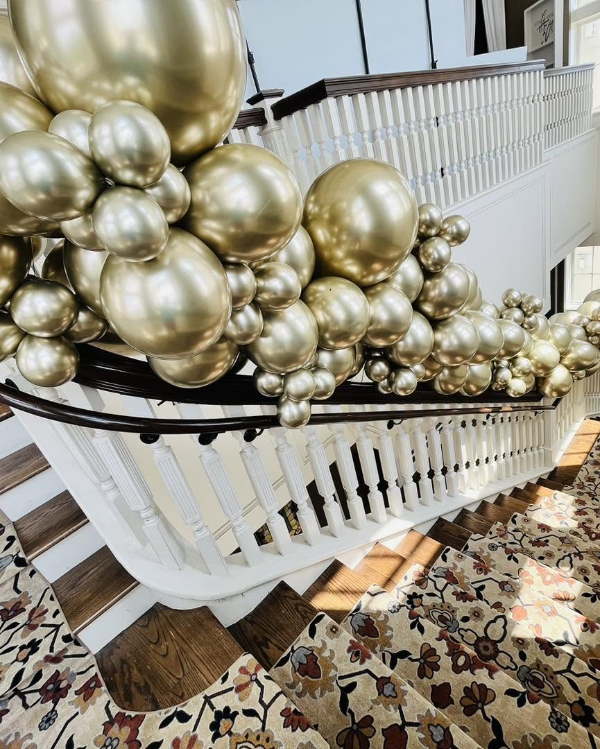 Balloon décor — Elegant gold balloon garland on a grand staircase