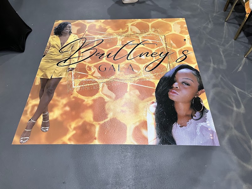 Custom gold floor decal reading Brittney's Gala at a formal event