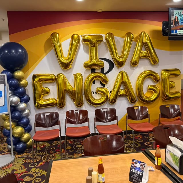 VIVA Engage corporate stage with gold balloon lettering