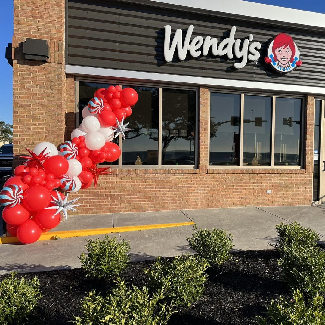 Red and white peppermint balloon garland framing a Wendy's storefront